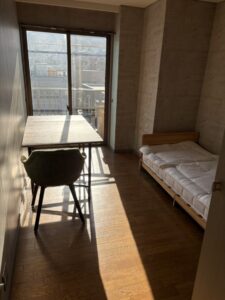 片付け前のオフィス。ベッド、机、イスが置かれている。