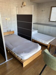 片付け前のオフィス。ベッド2点とパーテーション2点が置かれている。