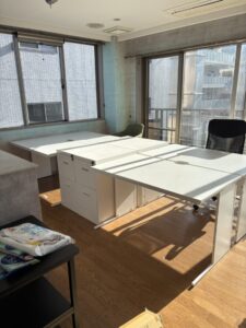 片付け前のオフィス。事務机とワゴンが置かれている。