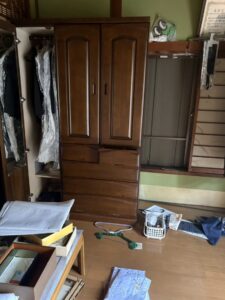 残置物撤去前　箪笥が置かれ生活用品が散らばっている。