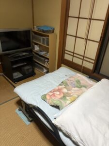 残置物撤去前　テレビ、布団、棚がある。