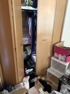 残置物撤去前のクローゼット。衣類やプラケースが散乱している