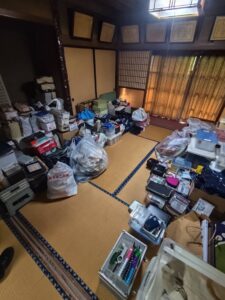 片付け前の和室。ゴミ袋や雑貨など不用品が床を半分ほど埋めている