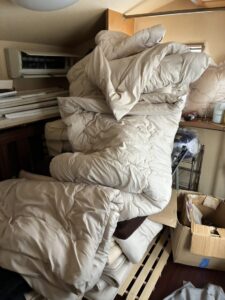 作業前の寝室。布団や解体されたベッドが積み上げられている。
