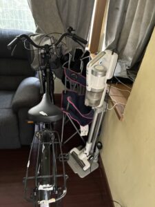 作業前のリビング。ソファーの脇に置かれた自転車と掃除機