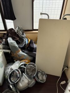 作業前の室内。衣類やコードなどが床に積み上がっている。