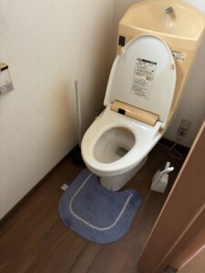 作業前のトイレ。トイレマットやトイレブラシ、スッポンが残されている。